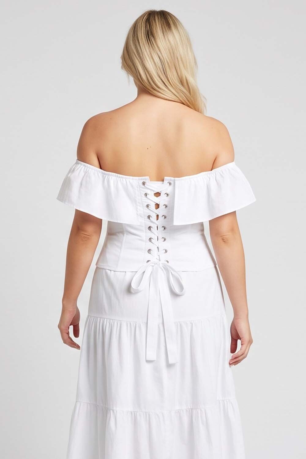 A woman shown from the LUXE NOIR CORSET back wearing a white off-the-shoulder dress with a lace-up back and tie detail, photographed against a light gray studio background.